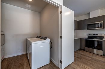 an empty kitchen with a washer and dryer and a refrigerator at Sagecrest Apartments, Wenatchee, WA